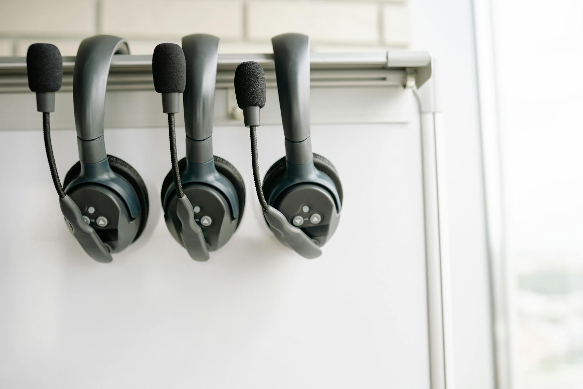 Three operator headsets racked above a dispatch board — the front desk this kit replaces with software